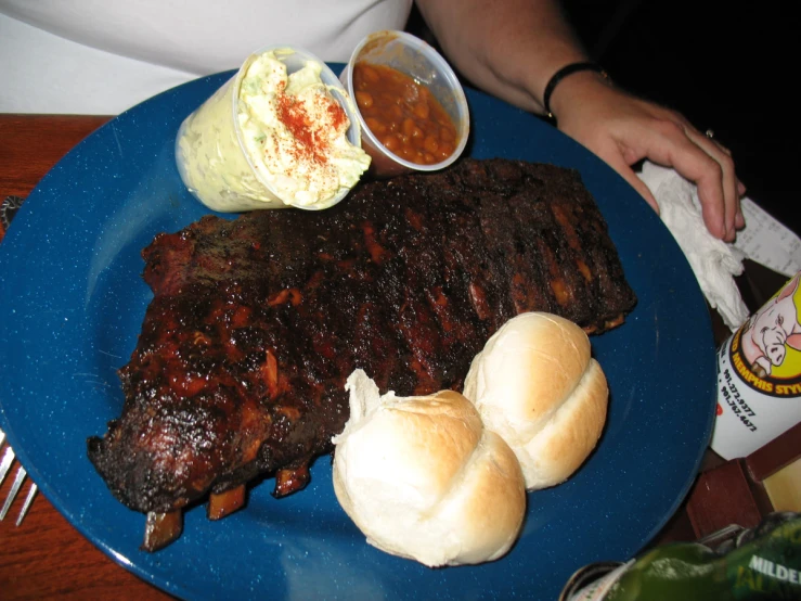 a plate with beef and buns, cole slaw and some sauce