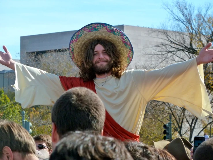 the man is dressed like jesus with his arms outstretched