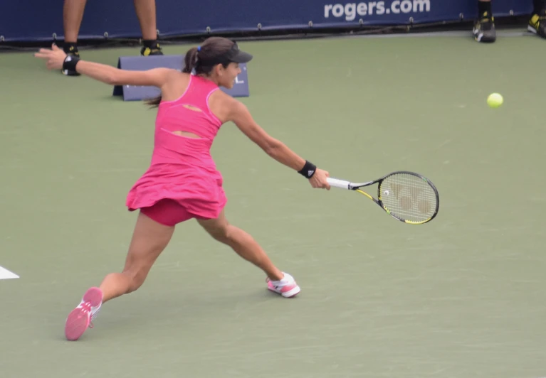 a girl hitting a tennis ball with her racket