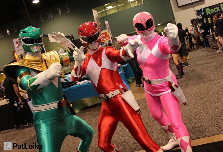 three people in costumes and masks posing for the camera