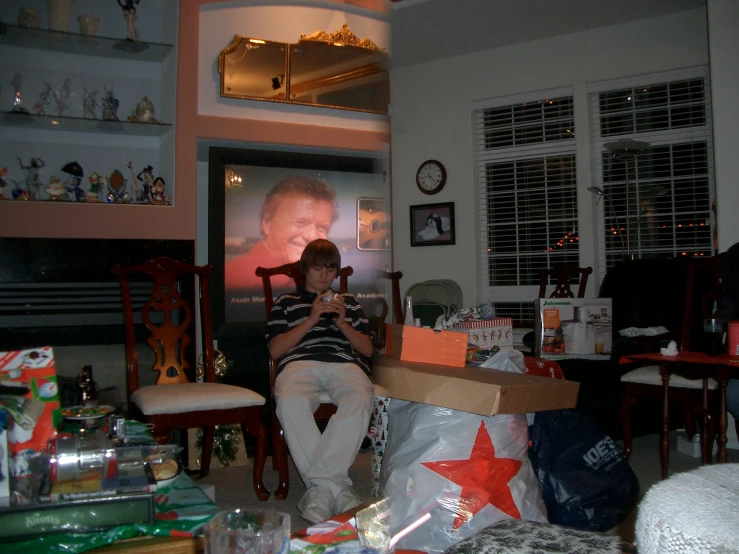 a man in a room filled with boxes, wrapped presents and wrapping