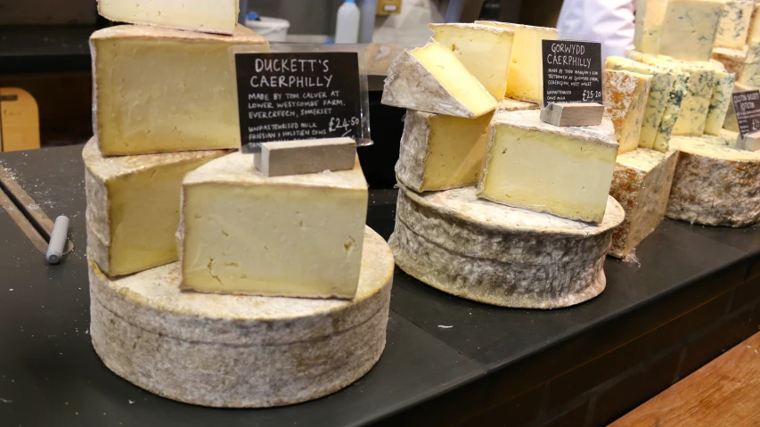 cheeses on a display for sale in a store