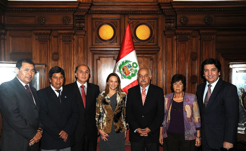 the two women are in suits with three men posing for a po