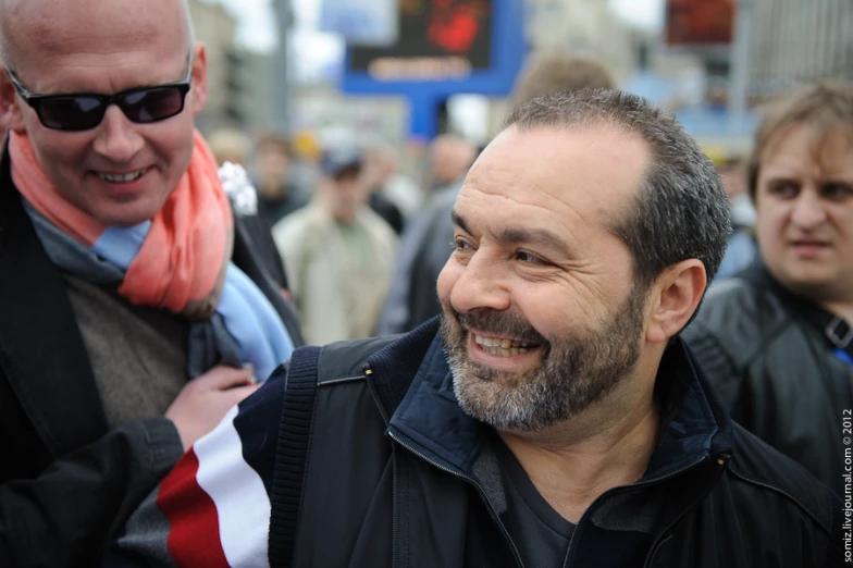 a man laughing in the crowd of people