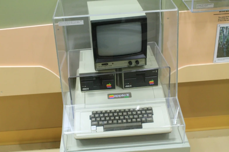 a display case holding an old computer, keyboard and monitor