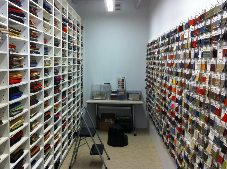 a room with rows of different colored papers and notebooks on the wall