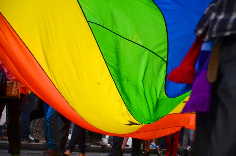 a multi - colored parachute flying over a group of people