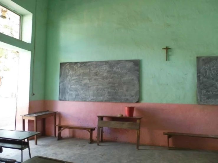 a room with chalkboards on the wall and two benches