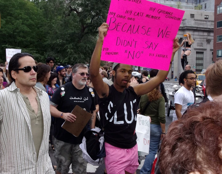 a man holding a sign in the street during a protest