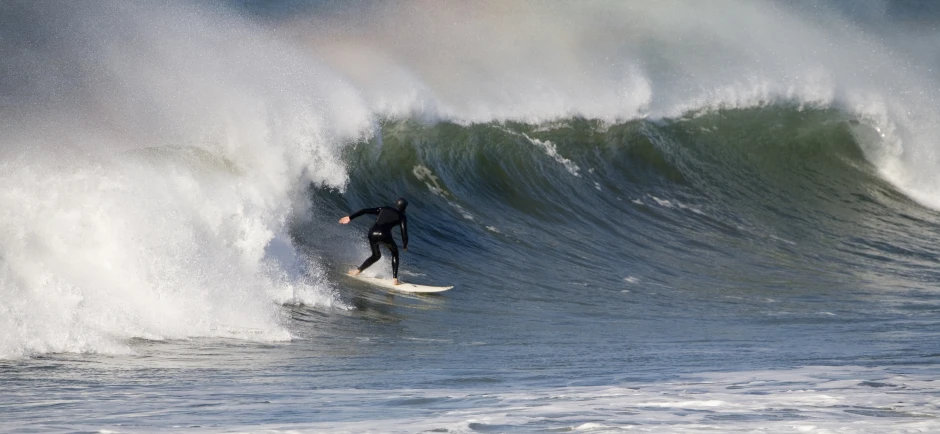 a person in a wet suit surfing in the ocean