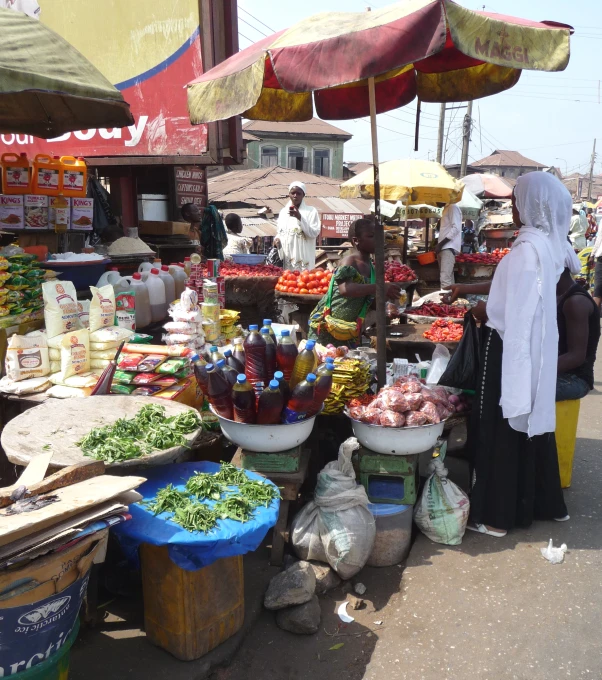 people at a market with a variety of food items