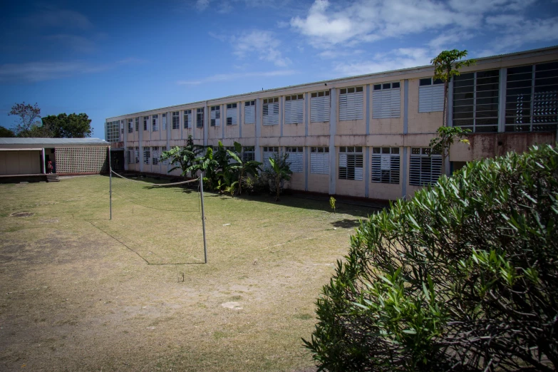 an abandoned school building and grassy field near trees