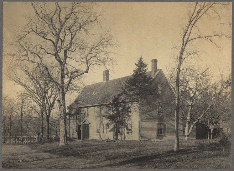 an old country house with trees and fence surrounding it