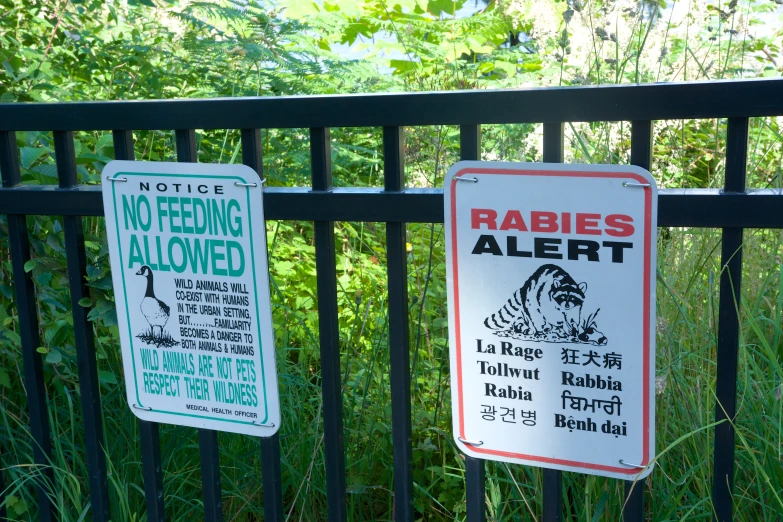 two signs next to the fence are warning people of the rights being allowed