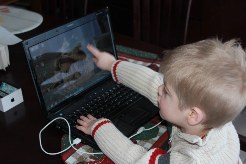 a child playing a video game on an open laptop