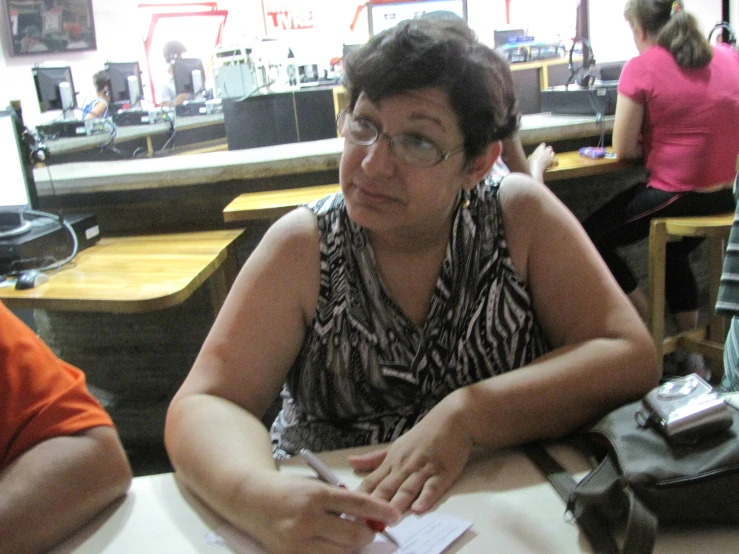 a woman sitting in a desk in front of some desks