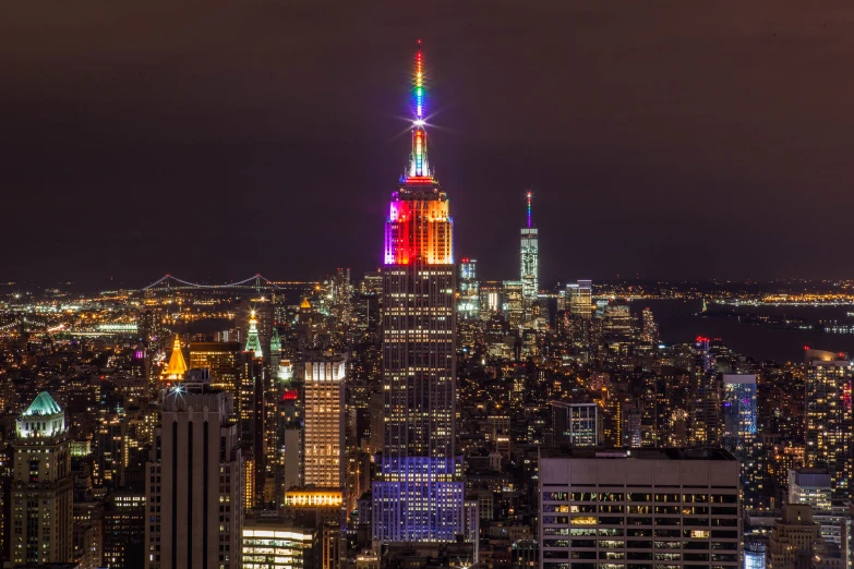 large skyscrs are lit up in rainbow colors