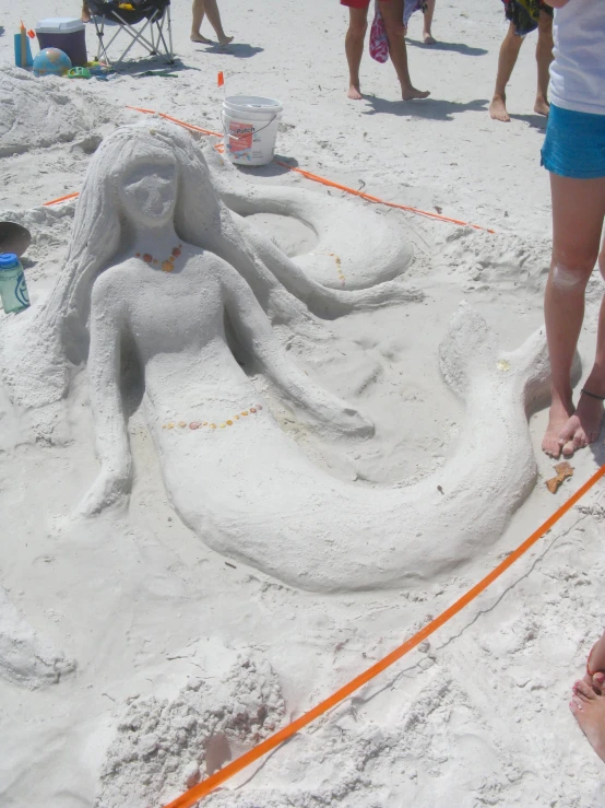 a woman walking toward a large white sand octo