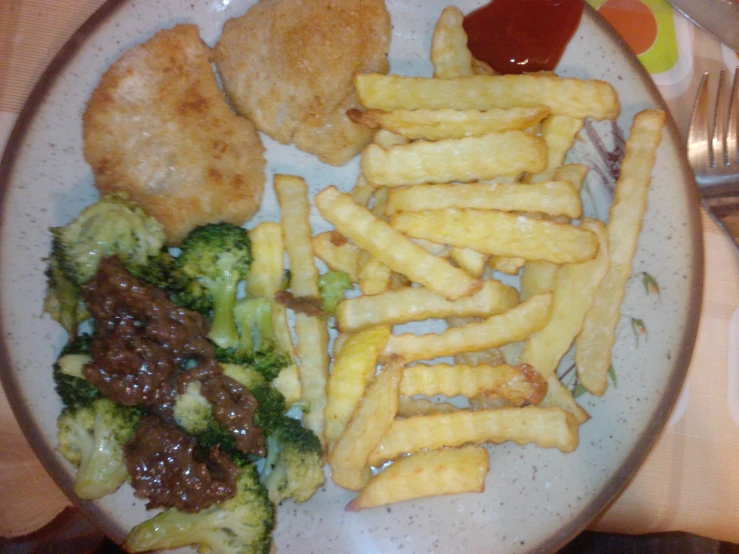 a plate filled with french fries and broccoli