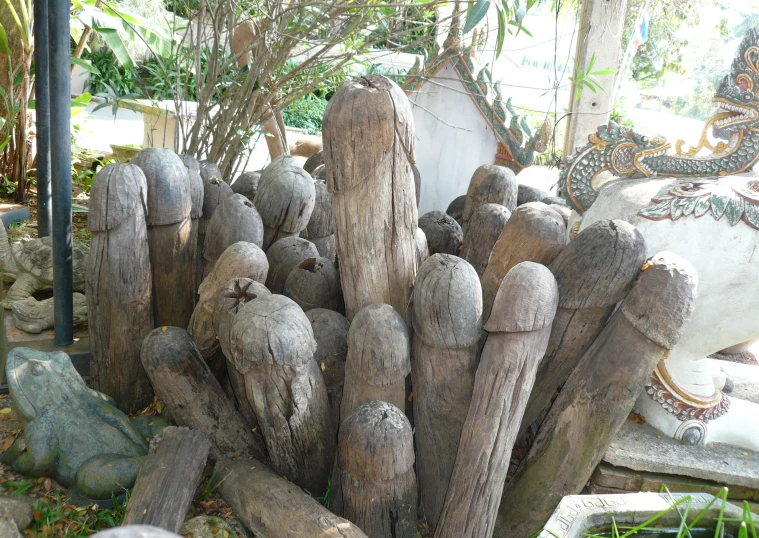 statues are in the grass behind a wooden fence