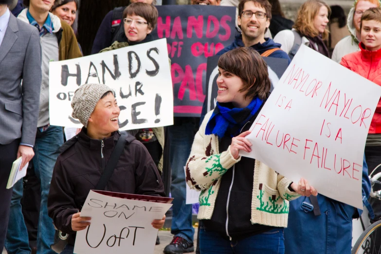 protesters hold signs and sing in a protest for the government