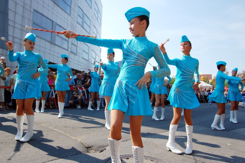 a group of girls dancing in blue outfits and white boots