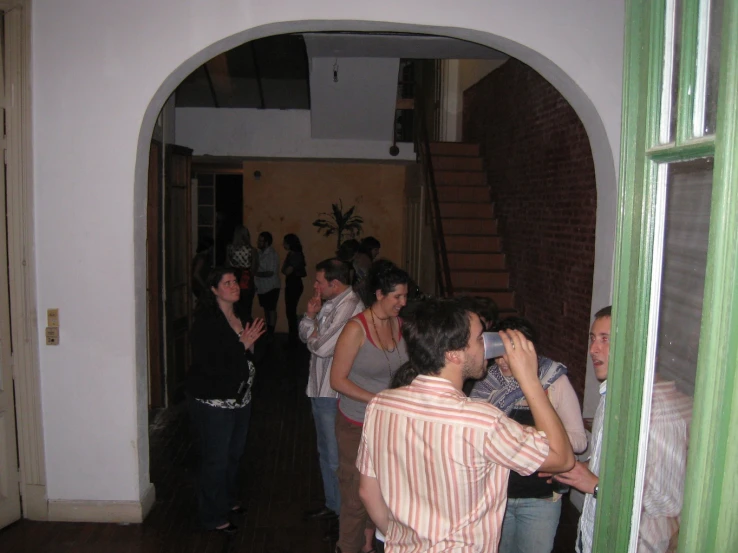 group of people standing in doorway with one person on cellphone