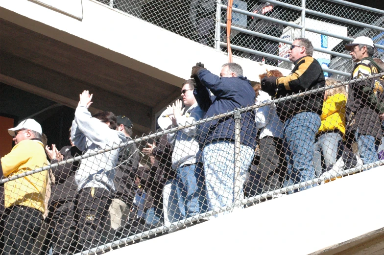 several people behind the fence watching soing by