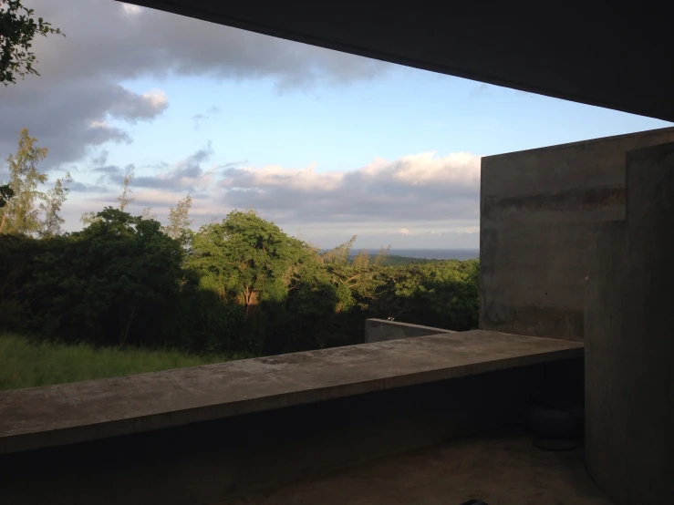 a lone bench near a concrete structure and green trees