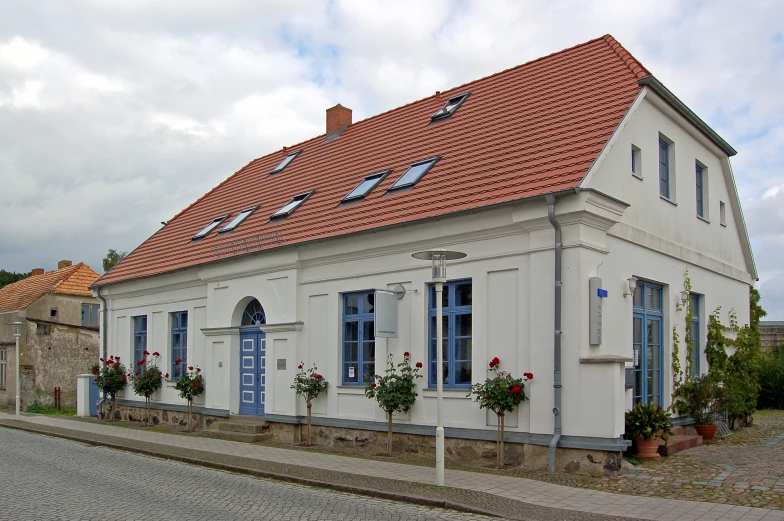 a white building with flowers in pots and window boxes