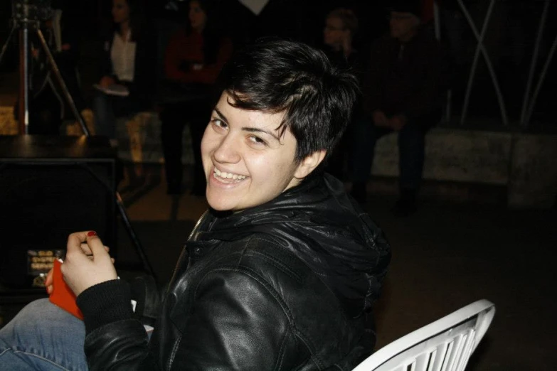 a woman in leather jacket smiling for the camera