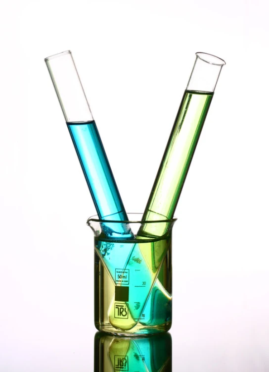 three test tubes containing colored liquid sitting inside of a small glass container