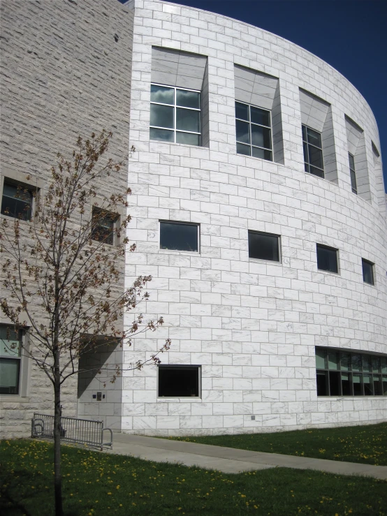 a white building sitting next to a green tree