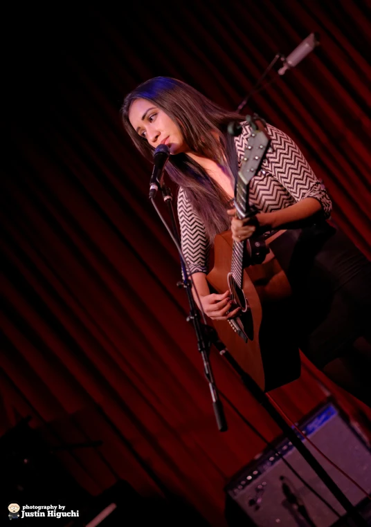 a girl that is standing up with a guitar