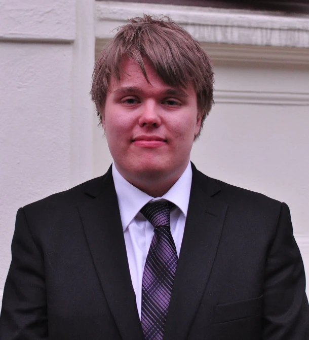 a man in a suit stands outside a building