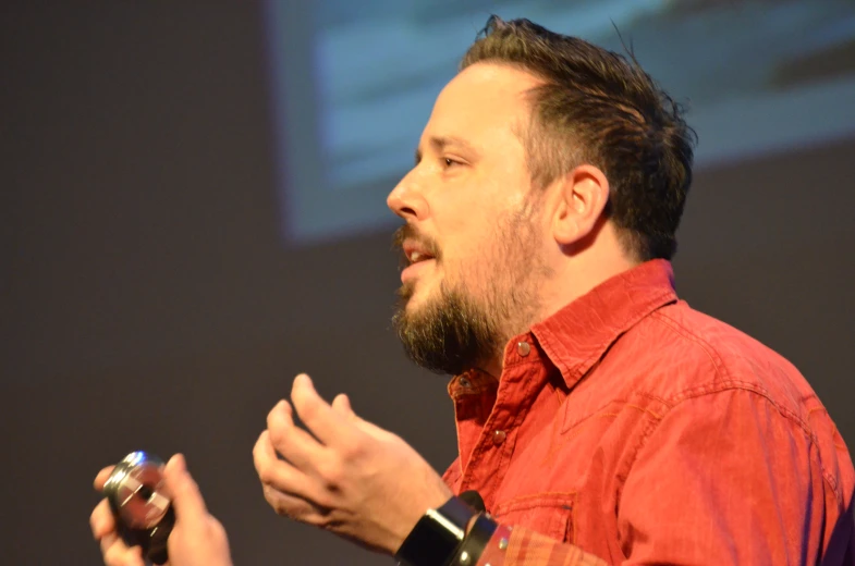 a man is talking on stage with other people