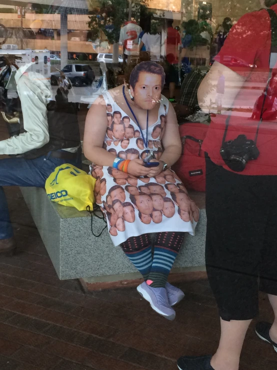 a mannequin wearing a dress with a large head sitting on a bench in front of a store