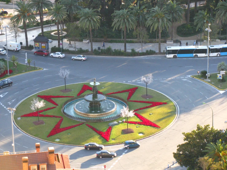 an intersection with a fountain and cars parked on the road