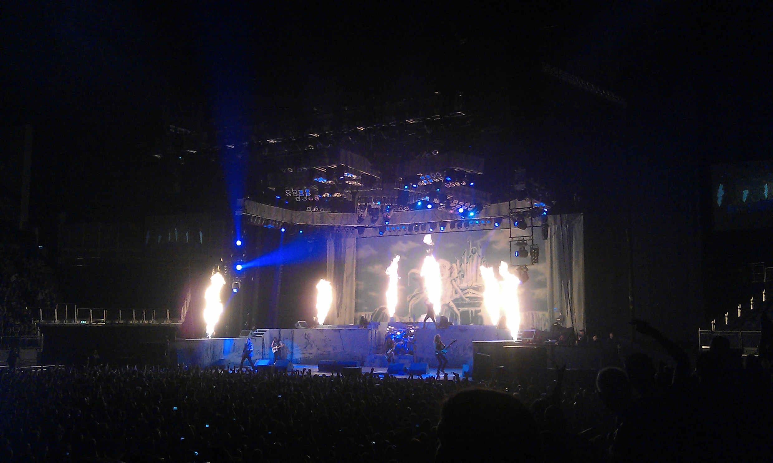 a stage is lit with white lights and bright fire