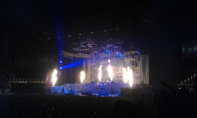 a stage is lit with white lights and bright fire