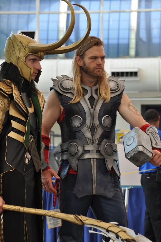 two men in cosplay with large horns and holding guns