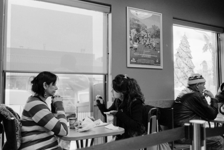 the woman are sitting at the table sharing a meal