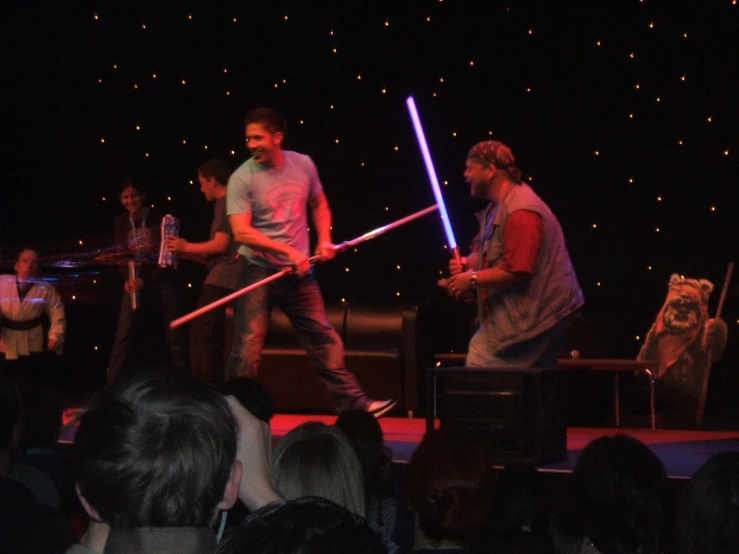 two men on stage with lights swords