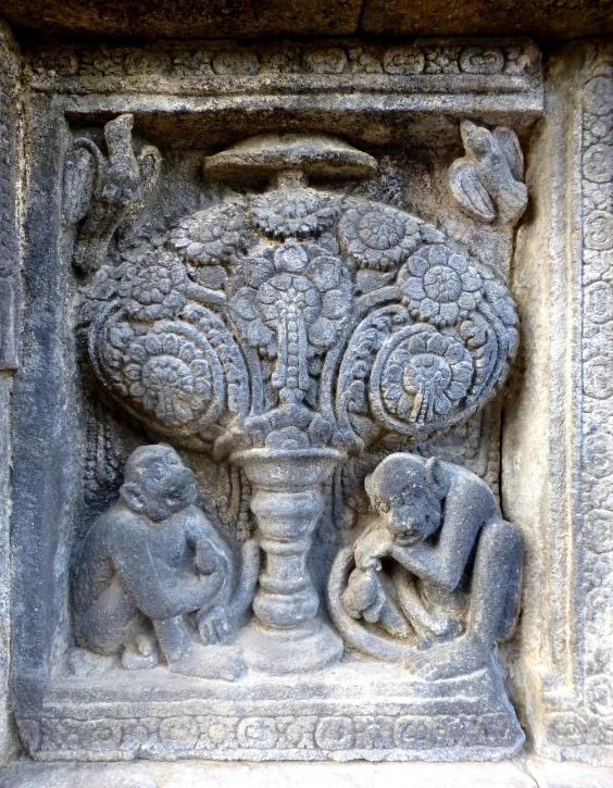 an elephant and its family basks on the wall of a temple