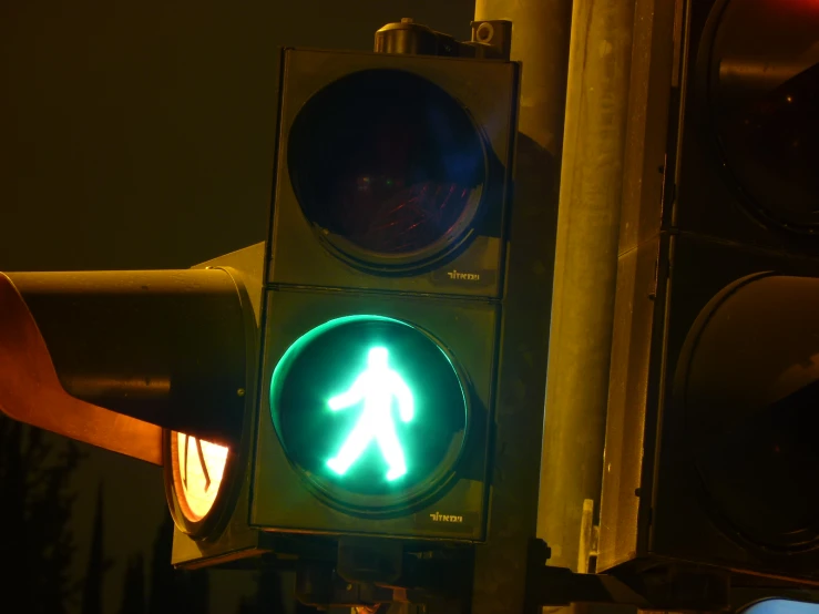 a stop light that is green and has a walk sign on it