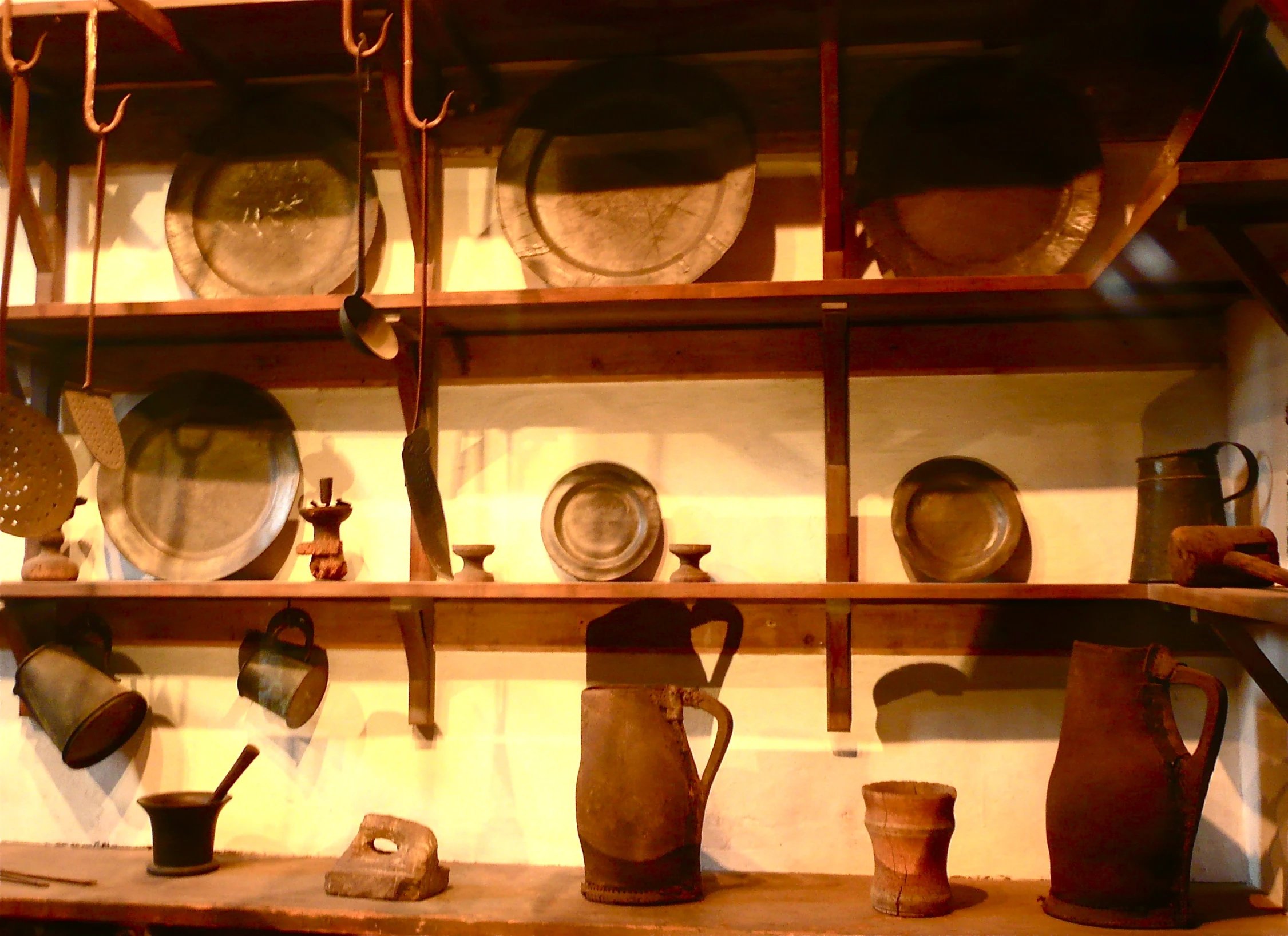 old pottery is displayed in a wall with many items