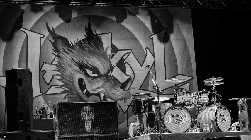 some large drum kits sit in front of a poster