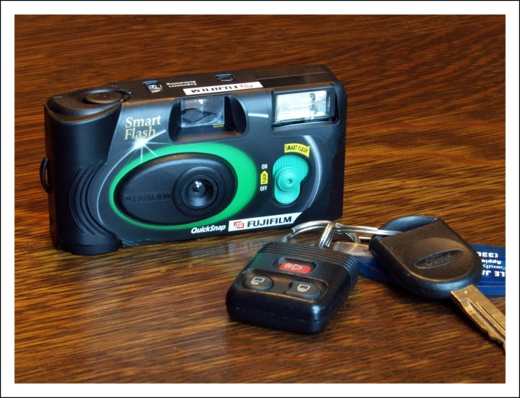 a small camera with keychains and a camera next to it