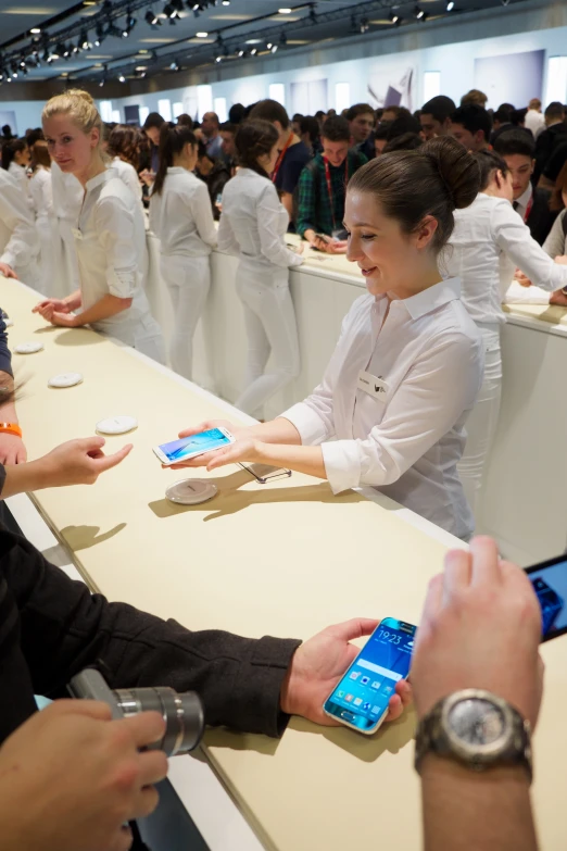 a crowd of people at a table with cell phones