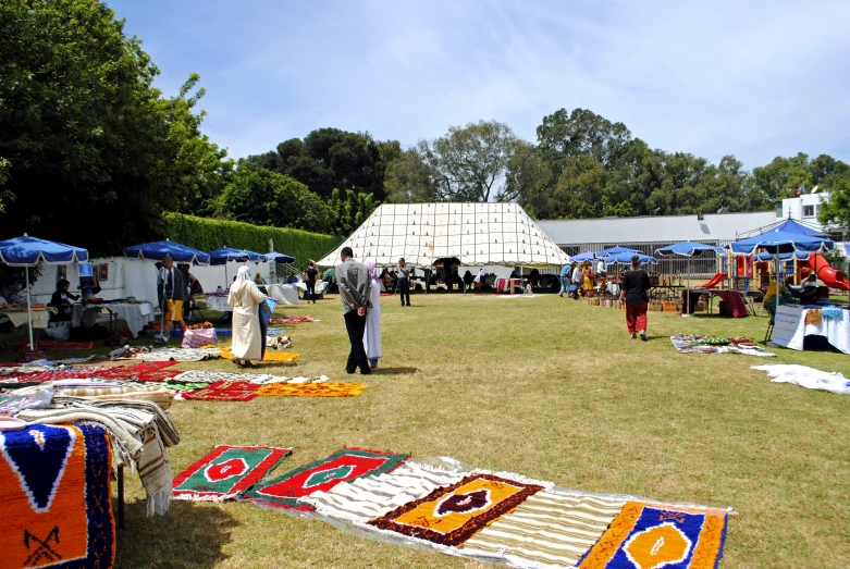 an area with tents, tables and people around